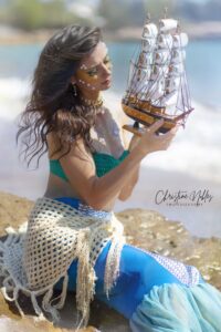 Mermaid holding boat on the beach 